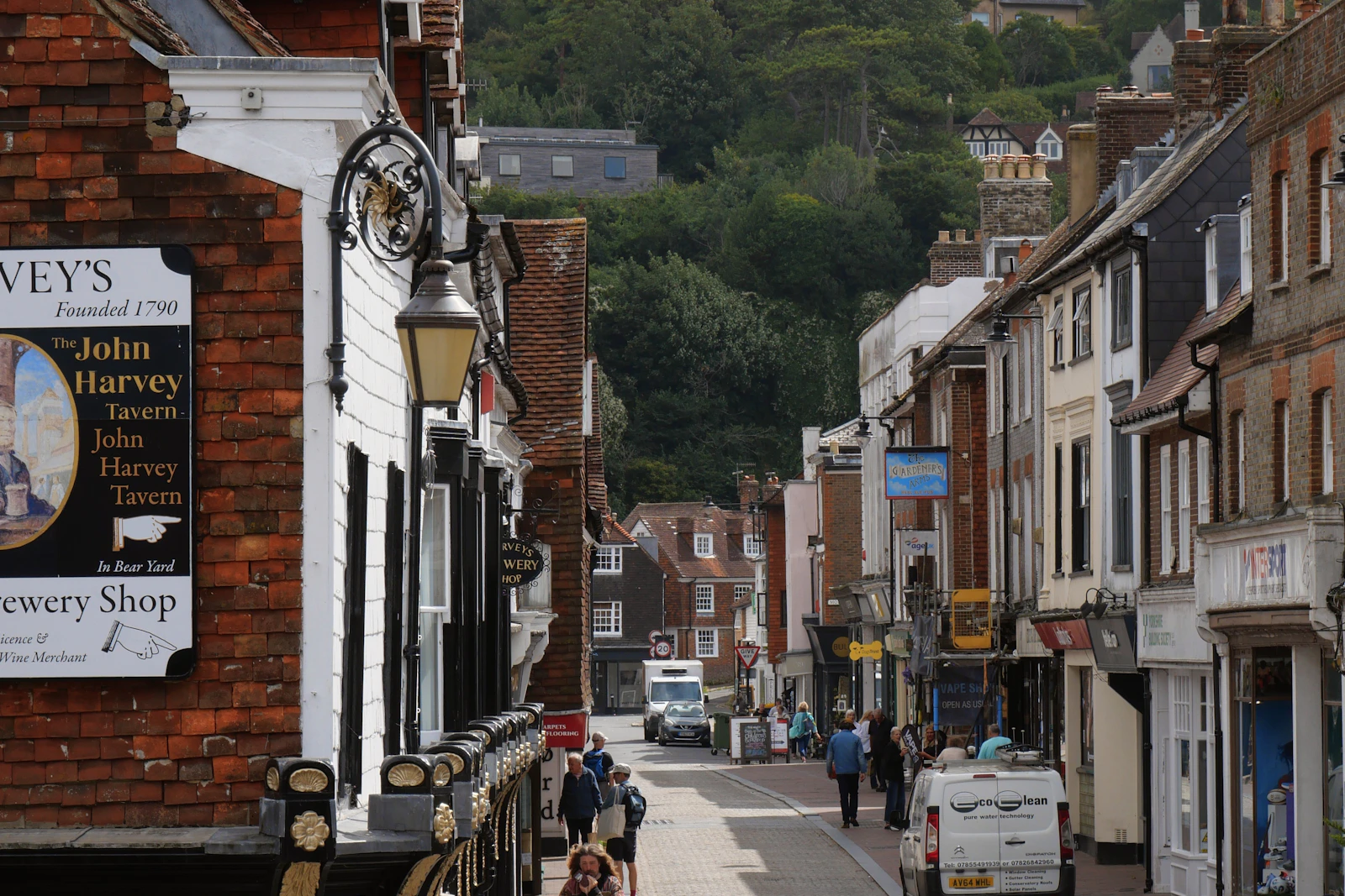 Historic buildings along a Lewes town street with a wooded hillside beyond, East Sussex